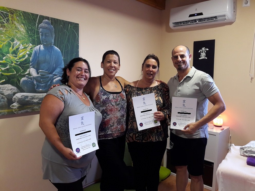 Grupo de personas con su diploma de Reiki
